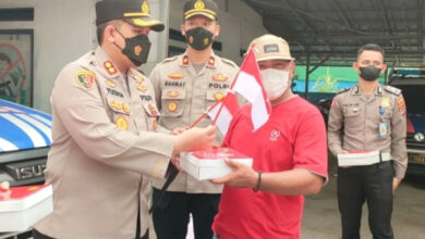 Kapolres Serang, AKBP Yudha Satria bagikan bendera dan nasi kota. Foto: Yono
