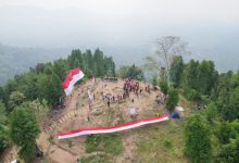 Pendaki gunung dan penggiat pariwisata membentangkan bendera raksasa di Gunung Gedor, Kota Serang. Foto Nana Amdan