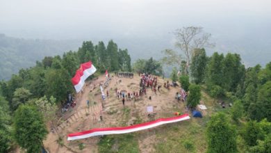 Pendaki gunung dan penggiat pariwisata membentangkan bendera raksasa di Gunung Gedor, Kota Serang. Foto Nana Amdan