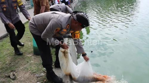 Kapolres Serang, AKBP Condro Sasongko menebar bibit ikan emas. Foto: Yono