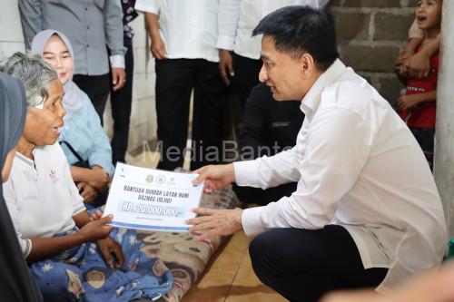 Wagub Banten, Achmad Dimyati Nataksumah menyerahkan bantuan renovasi rumah. Foto Biro Adpim Banten