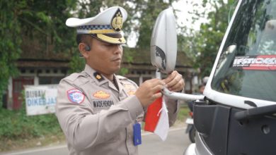 Personel Ditlantas Polda Banteng memasang bendera merah putih di kenadaraan. Foto: Bidhumas Polda Banten