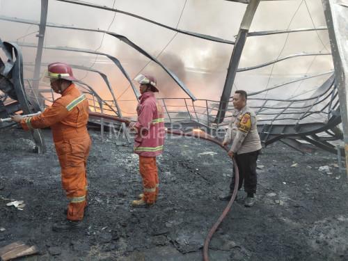 Petugas Damkar dan polisi berjibaku padamkan gudang penyimpanan bahan plastik yang terbakar di Jawilan. Foto Yono