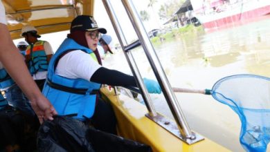 Intan Nurul Hikmah, Wakil Bupati Tangerang tengah menyerok sampah di Sungan Tanjung Burung. Foto: Antara