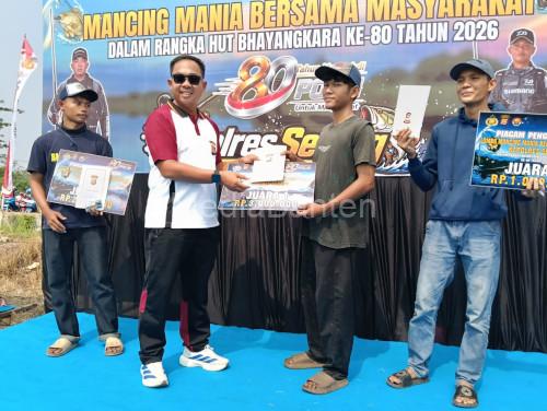 Kapolres Serag, AKBP Andri Kurniawan menyerahkan hadiah juara petama lomb memancing mania. Foto Yono