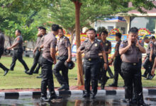 Personel Polres Serang yang naik pangkat diguyur air. Foto: Yono