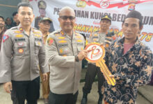 Kapolres Serang, AKBP Condro Sasongko menyerahkan kunci hasil bedah rumah ke guru ngaji. Foto: Yono