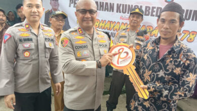 Kapolres Serang, AKBP Condro Sasongko menyerahkan kunci hasil bedah rumah ke guru ngaji. Foto: Yono