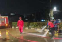 Petugas BPBD Kota Tangerang bersihkan jalan ke Asrama Haji Banten. Foto: LKBN Antara