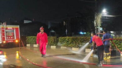 Petugas BPBD Kota Tangerang bersihkan jalan ke Asrama Haji Banten. Foto: LKBN Antara
