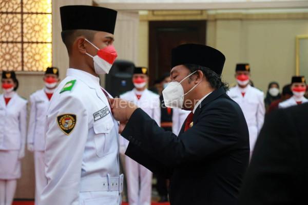Pj Gubernur Banten, Al Muktabar menyematkan pin Paskibraka. Foto: Biro Adpim Banten