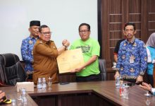 Pj Gubernur Banten, Abdul Rouf Damenta menyerahkan SK penetapan upah minimum kabupaten / kota ke buruh. Foto: Biro Adpim Banten