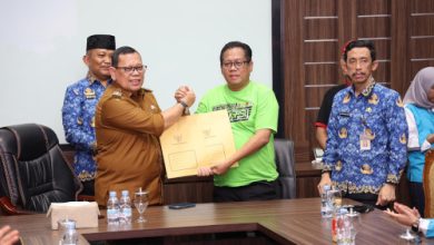 Pj Gubernur Banten, Abdul Rouf Damenta menyerahkan SK penetapan upah minimum kabupaten / kota ke buruh. Foto: Biro Adpim Banten