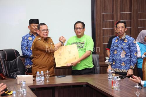 Pj Gubernur Banten, Abdul Rouf Damenta menyerahkan SK penetapan upah minimum kabupaten / kota ke buruh. Foto: Biro Adpim Banten