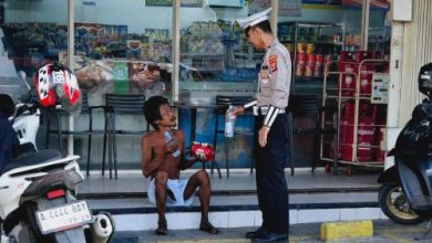 Aipa Kusnandar, anggota Polantas membantu ODGJ menyeberang di Ciruas. Foto: Yono