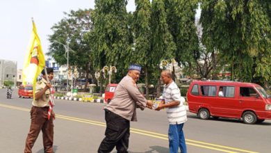 Kasatbinmas Polres Cilegon, Iptu Muhyidin tengah membagikan nasi bungkus dalam Jumat Berkah. Foto Daeng Yusvin