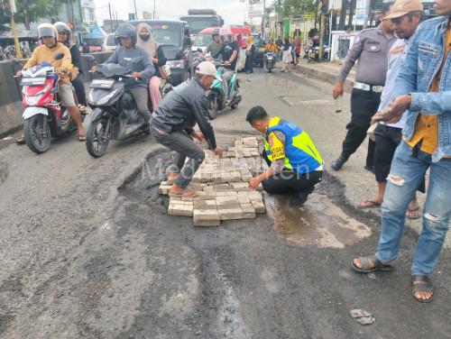 Unit Gakum Satlantas Polres Serang tengah melakukan perbaikan jalan berlubang. Foto Yono