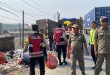 Polsek Cikande ikut membersihkan tumpukan sampah liar di pinggi jalan. Foto Yono