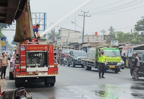 Polsek Cikande melakukan penyiraman debu jalanan dan distribusikan air bersih. Foto Yono