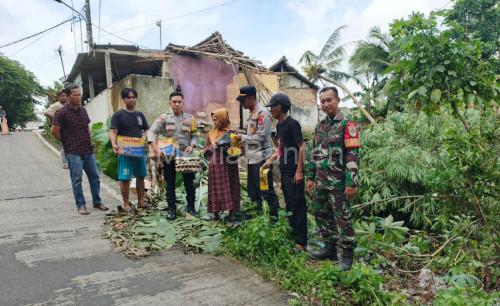 Polsek Cikeusal membantu 2 pemilik rumah korban tanah longsor di Desa Cidahu. Foto Yono