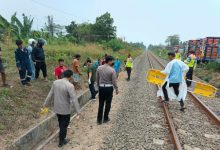 Petugas tengah mengevakuasi jasad sopir truk ditabrak kereta api di Bogeg. Foto Yono