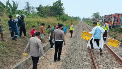 Petugas tengah mengevakuasi jasad sopir truk ditabrak kereta api di Bogeg. Foto Yono