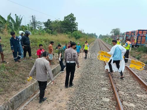 Petugas tengah mengevakuasi jasad sopir truk ditabrak kereta api di Bogeg. Foto Yono