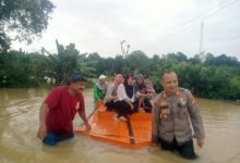 Korban banjir di Binuang diseberangkan dengan rakit oleh petugas Polsek Jawilan. Foto Yono