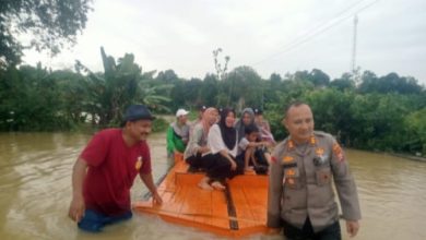 Korban banjir di Binuang diseberangkan dengan rakit oleh petugas Polsek Jawilan. Foto Yono