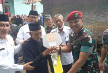 Dangrup 1 Kopassus Serang, Kolonel Romel Jangga Wardana menyerahkan kunci ke Jaenul, pemilik rumah yang direnovasi. Foto: Aden Hasanudin