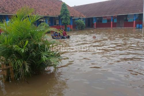 Murid SDN 1 Cibeureum terpaksa diliburkan karena sekolahnya terendam banjir. Foto: Antara