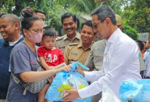 Pj Gubernur DKI Jakarta, Heru Budi Hartono menyerakan paket sembako murah ke seorang warga. Foto: Diskominfotik DKI Jakarta
