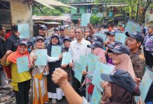 Pj Gubernur DKI Jakarta, Heru Budi Hartono menyerahkan sertifikat tanah warga. Foto: Diskominfotik DKI