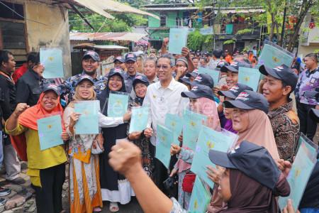 Pj Gubernur DKI Jakarta, Heru Budi Hartono menyerahkan sertifikat tanah warga. Foto: Diskominfotik DKI