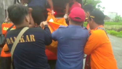 Tim SAR Gabungan tengah mengangkat jasad korban tenggelam di Sungai Cidurian. Foto: Yono